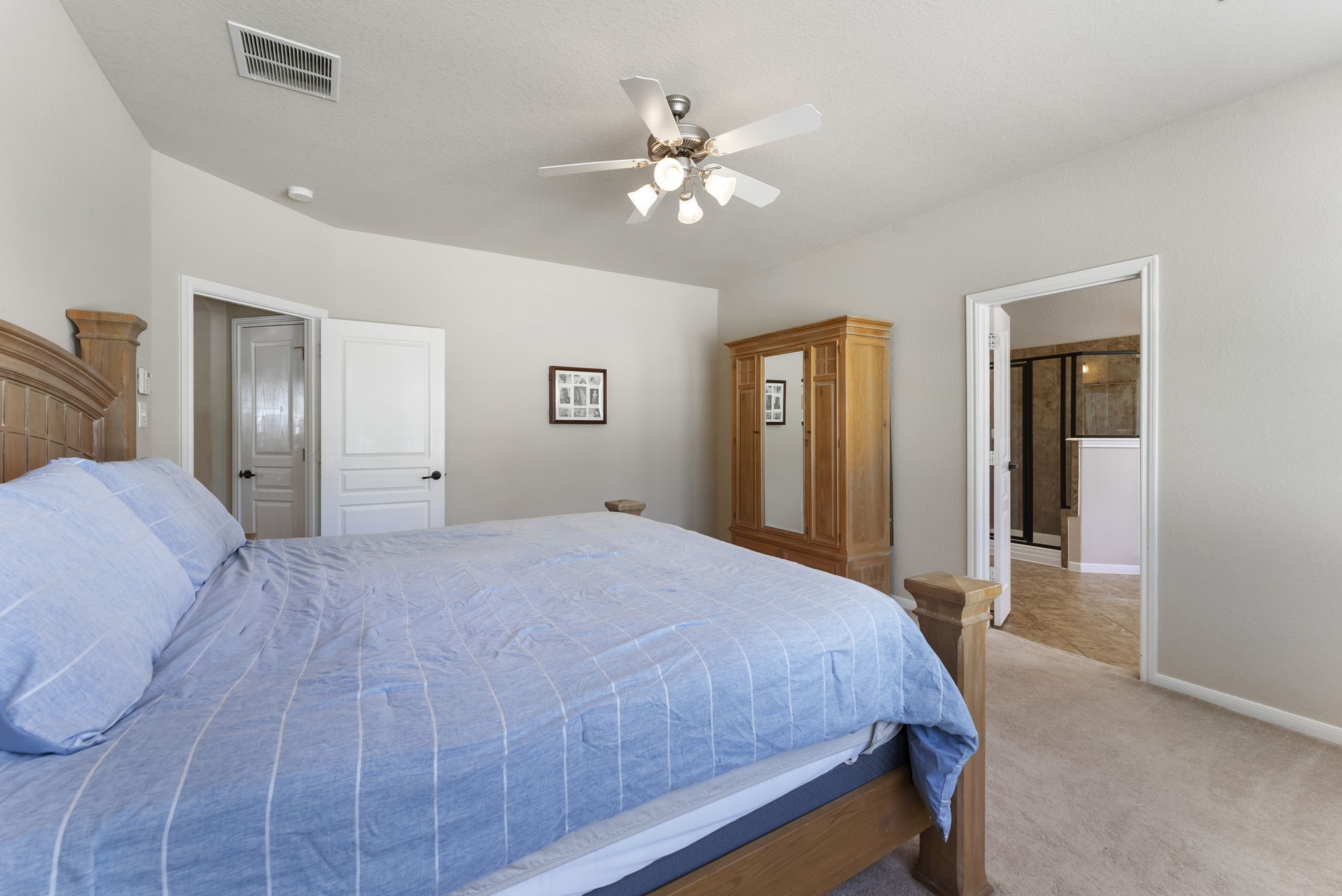 19223 Senterra Lakes Boulevard Spring, TX 77379 - Photo 16 of 48 a bedroom with a large bed and a chandelier