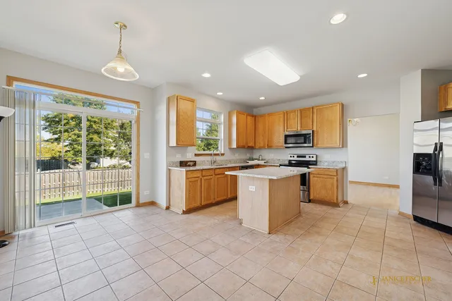 a kitchen with a refrigerator a stove top oven a sink dishwasher and white cabinets with wooden floor