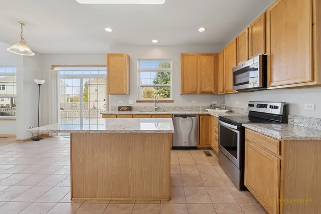 a kitchen with stainless steel appliances granite countertop a stove a sink and a microwave