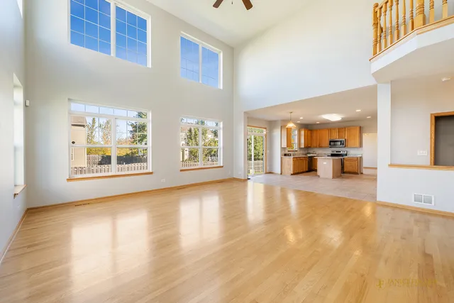a view of empty room with wooden floor and windows
