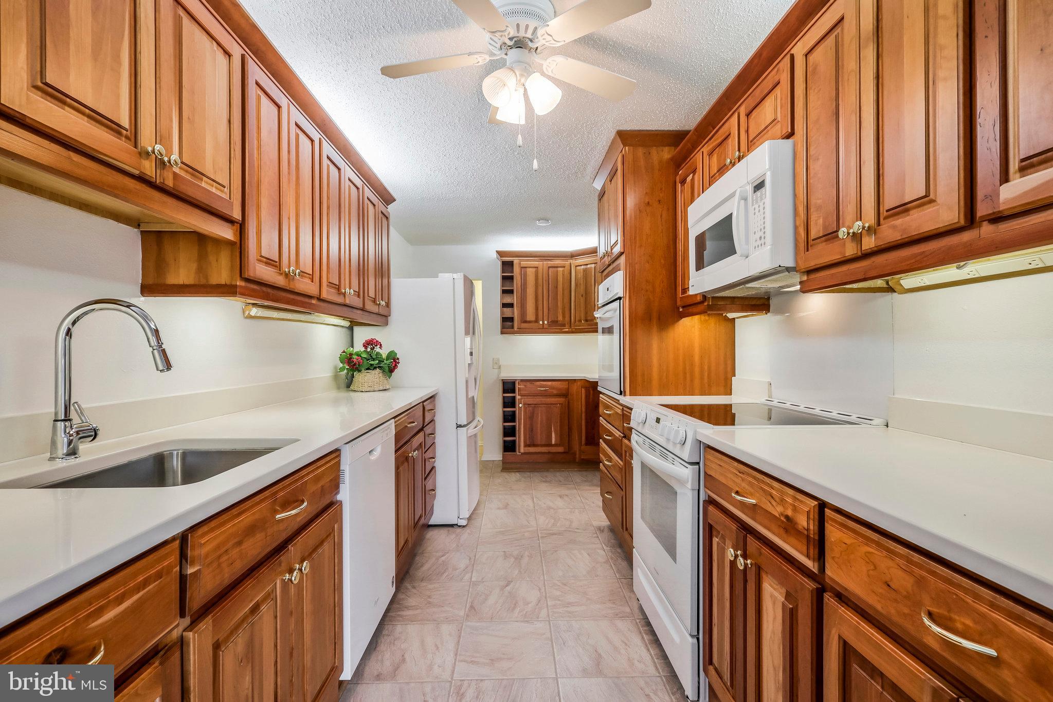 6101 Edsall Road, Unit 712 Alexandria, VA 22304 - Photo 11 of 53 a kitchen with stainless steel appliances granite countertop a sink and dishwasher a stove top oven with wooden floor
