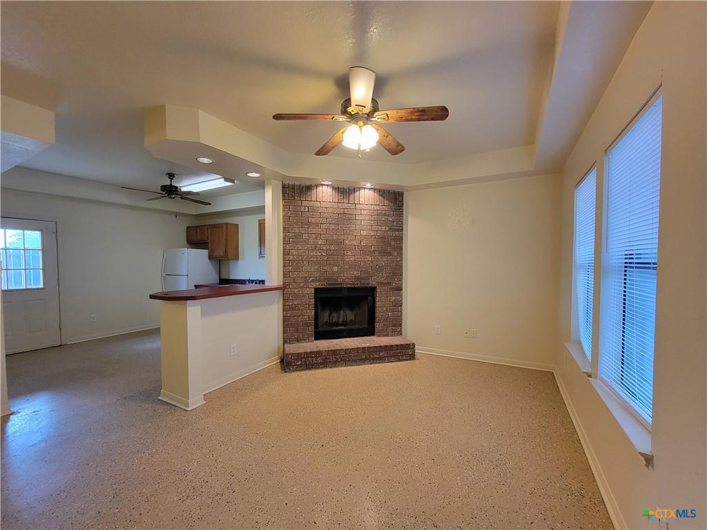 10413 Trimmier Road Killeen, TX 76542 - Photo 3 of 8 A welcoming living space features a cozy brick fireplace and an open layout connecting to the kitchen.