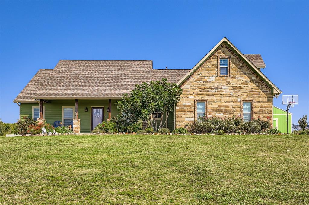 785 Schneider Road Howe, TX 75459 - Photo 1 of 40 View of front of house featuring a front lawn, a porch, roof with shingles, and stone siding