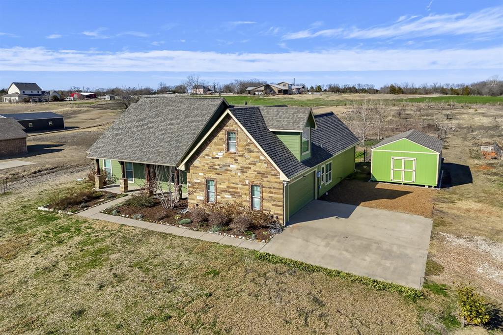785 Schneider Road Howe, TX 75459 - Photo 2 of 40 View of front of property featuring a shed, covered porch, a shingled roof, stone siding, and driveway