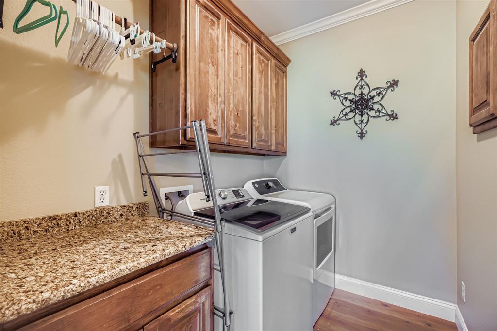 785 Schneider Road Howe, TX 75459 - Photo 29 of 40 Laundry area with ornamental molding, cabinet space, washing machine and dryer, and light wood-style floors