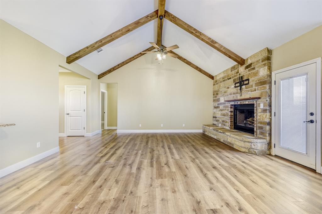 785 Schneider Road Howe, TX 75459 - Photo 6 of 40 Unfurnished living room with a fireplace, light wood-style flooring, and ceiling fan