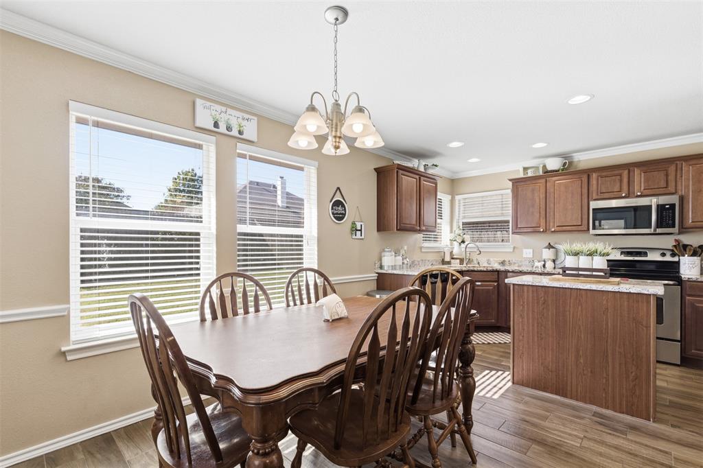 814 Chestnut Grove Drive Cleburne, TX 76033 - Photo 15 of 40 a dining room with wooden floor a chandelier a wooden table and chairs