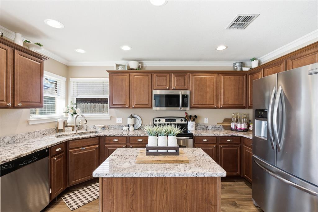 814 Chestnut Grove Drive Cleburne, TX 76033 - Photo 16 of 40 a kitchen with stainless steel appliances granite countertop a sink stove refrigerator and cabinets