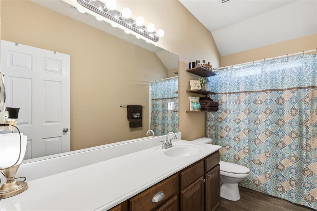 814 Chestnut Grove Drive Cleburne, TX 76033 - Photo 27 of 40 a bathroom with a sink a toilet and a mirror