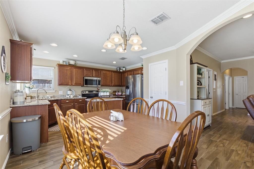 814 Chestnut Grove Drive Cleburne, TX 76033 - Photo 30 of 40 a view of a dining room with furniture a chandelier and wooden floor