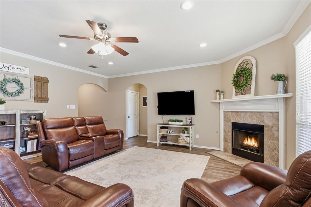 814 Chestnut Grove Drive Cleburne, TX 76033 - Photo 8 of 40 a living room with furniture a flat screen tv and a fireplace