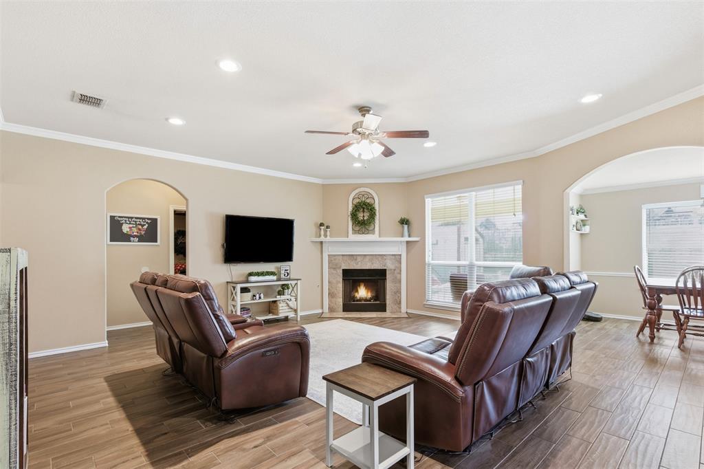 814 Chestnut Grove Drive Cleburne, TX 76033 - Photo 9 of 40 a living room with furniture a fireplace and a flat screen tv