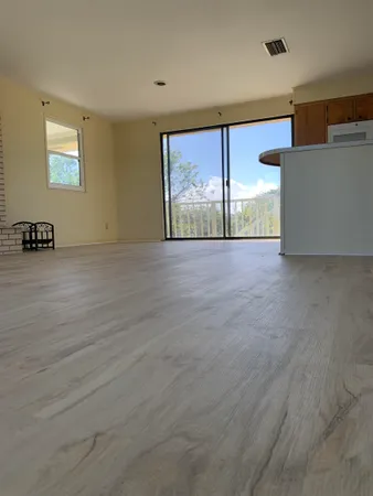 an empty room with windows and fireplace