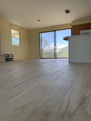 an empty room with windows and fireplace