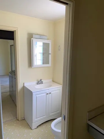 a kitchen with cabinets and wooden floor