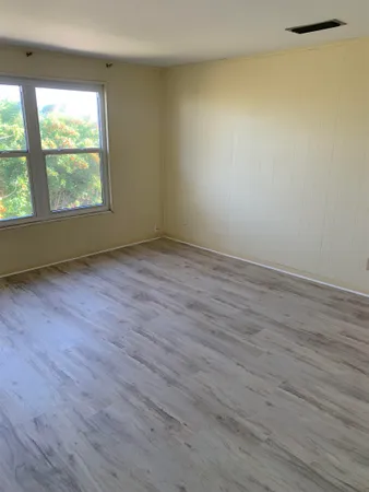 an empty room with windows and fireplace