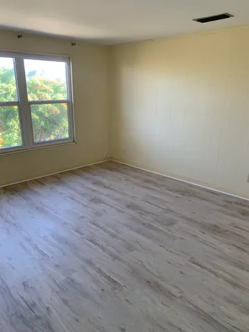 an empty room with windows and fireplace