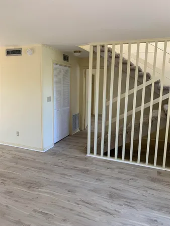 an empty room with wooden floor and closet