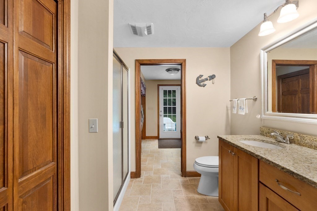 271 Pine Street Marshfield, MA 02050 - Photo 20 of 41 a bathroom with a granite countertop toilet a sink and a mirror