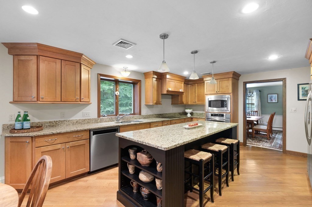 271 Pine Street Marshfield, MA 02050 - Photo 5 of 41 a kitchen with stainless steel appliances granite countertop a stove a sink dishwasher and a refrigerator with wooden cabinets