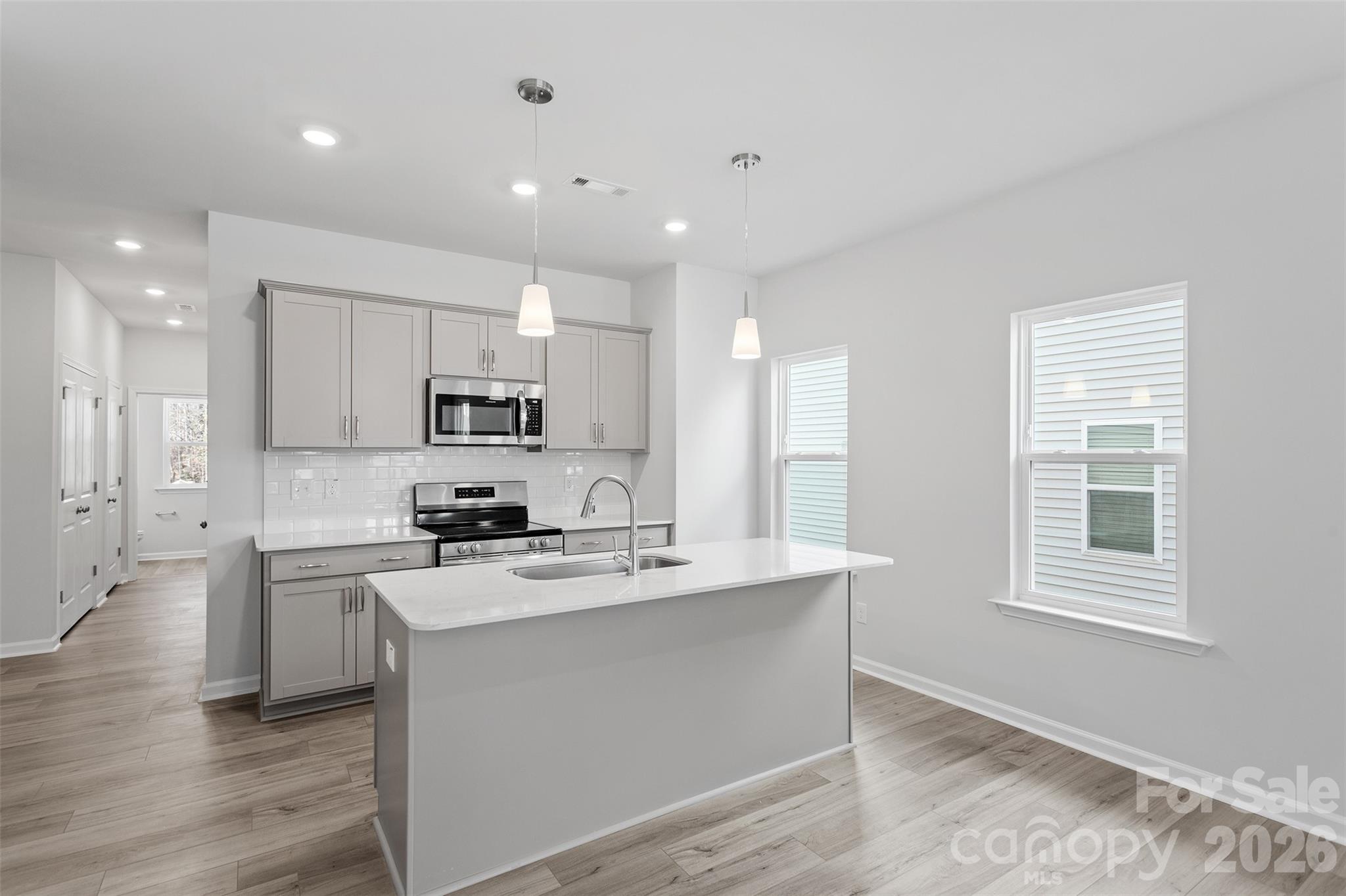 5869 Tuckaseegee Road, Unit 1 Charlotte, NC 28208 - Photo 6 of 30 a kitchen with a stove a sink and a refrigerator