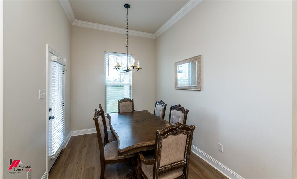 331 Hummingbird Lane Princeton, LA 71067 - Photo 11 of 34 Dining space featuring ornamental molding, wood finished floors, and a chandelier