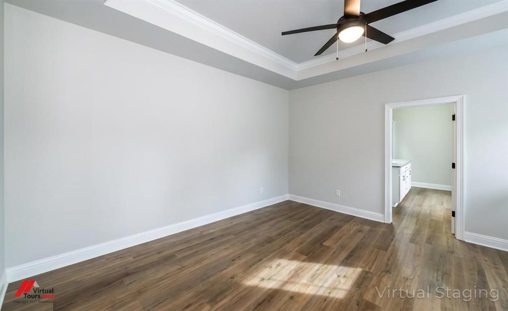 331 Hummingbird Lane Princeton, LA 71067 - Photo 16 of 34 AI Virtually removed furniture. Unfurnished room featuring a raised ceiling, ceiling fan, dark wood-style flooring, and ornamental molding