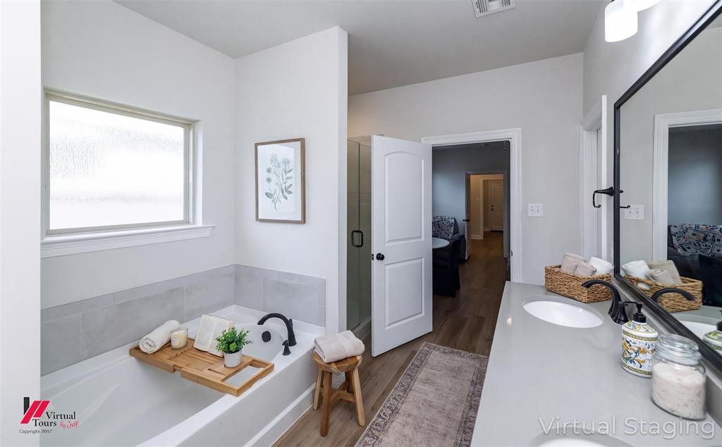 331 Hummingbird Lane Princeton, LA 71067 - Photo 18 of 34 AI Virtually staged. Bathroom featuring vanity, a bath, ensuite bath, a shower stall, and light wood-type flooring
