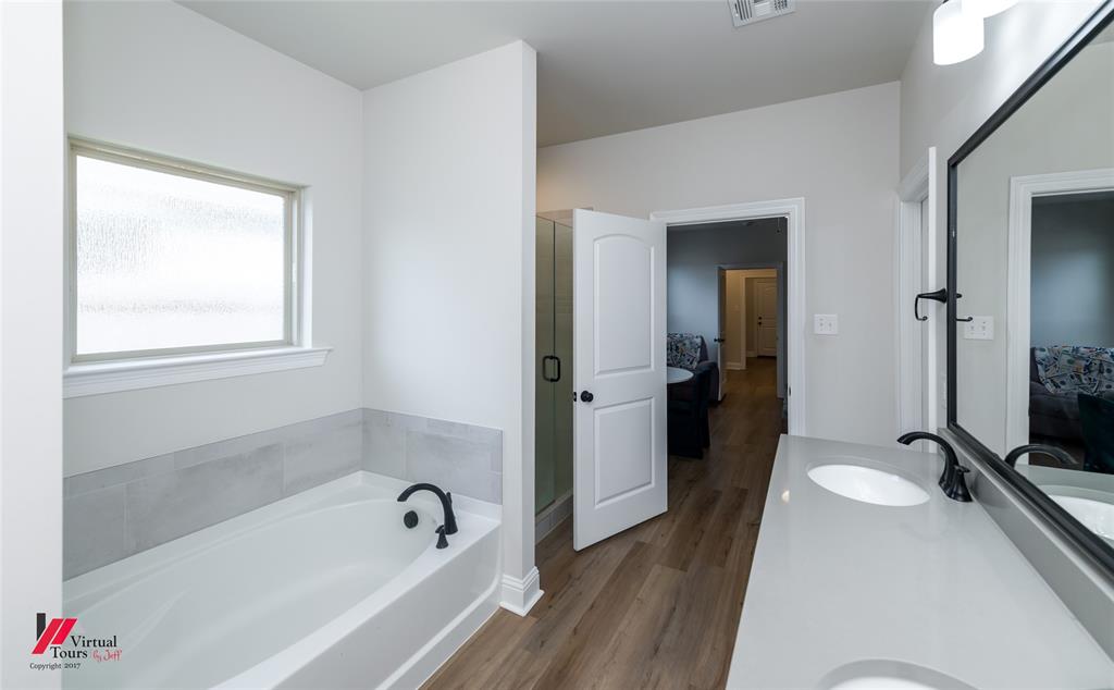 331 Hummingbird Lane Princeton, LA 71067 - Photo 19 of 34 Ensuite bathroom featuring a garden tub, vanity, a shower stall, and dark wood-type flooring