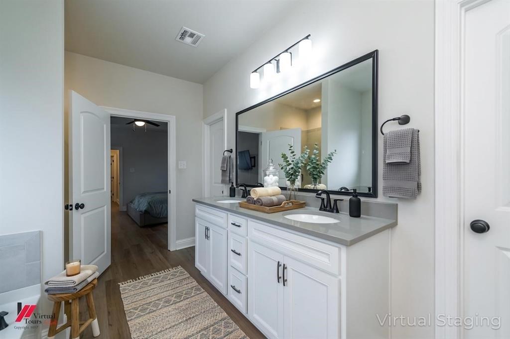331 Hummingbird Lane Princeton, LA 71067 - Photo 21 of 34 AI Virtually added some staging. Ensuite bathroom featuring double vanity and dark wood-style floors