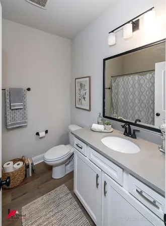 a bathroom with a granite countertop toilet sink and mirror