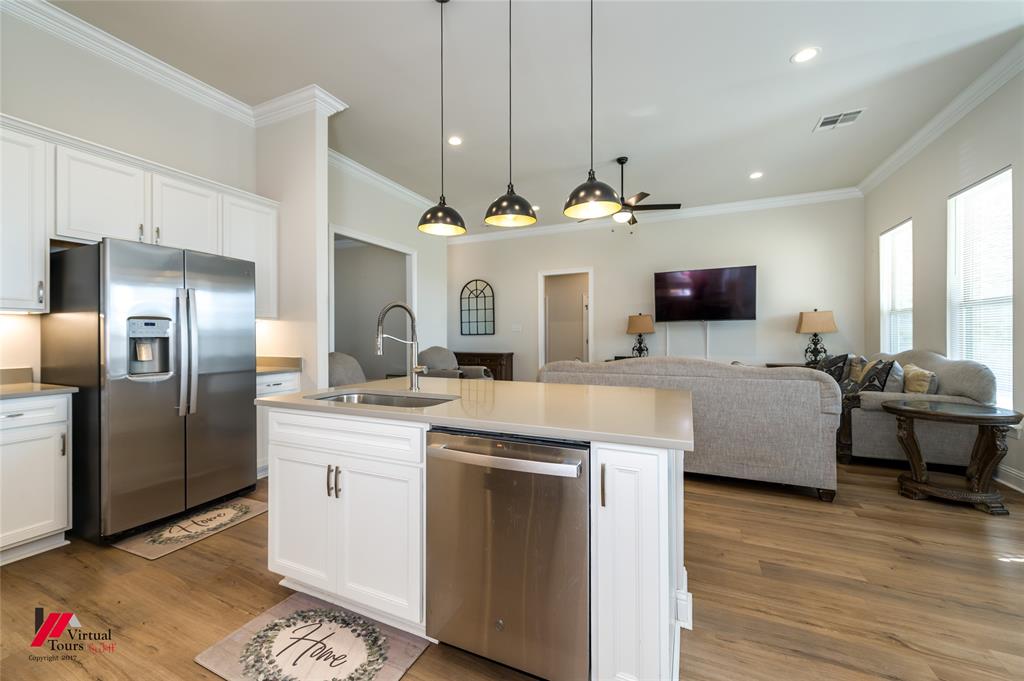 331 Hummingbird Lane Princeton, LA 71067 - Photo 34 of 34 Kitchen featuring stainless steel appliances, open floor plan, a kitchen island with sink, white cabinets, and light wood-type flooring