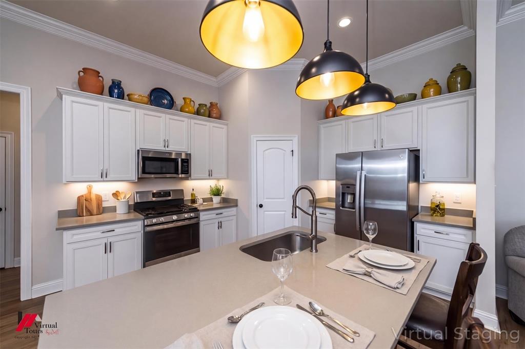 331 Hummingbird Lane Princeton, LA 71067 - Photo 5 of 34 AI Virtually added some staging. Kitchen with stainless steel appliances, white cabinets, decorative light fixtures, and crown molding