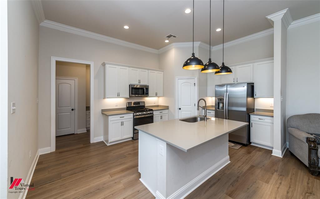 331 Hummingbird Lane Princeton, LA 71067 - Photo 6 of 34 Kitchen with white cabinets, stainless steel appliances, an island with sink, crown molding, and dark wood finished floors