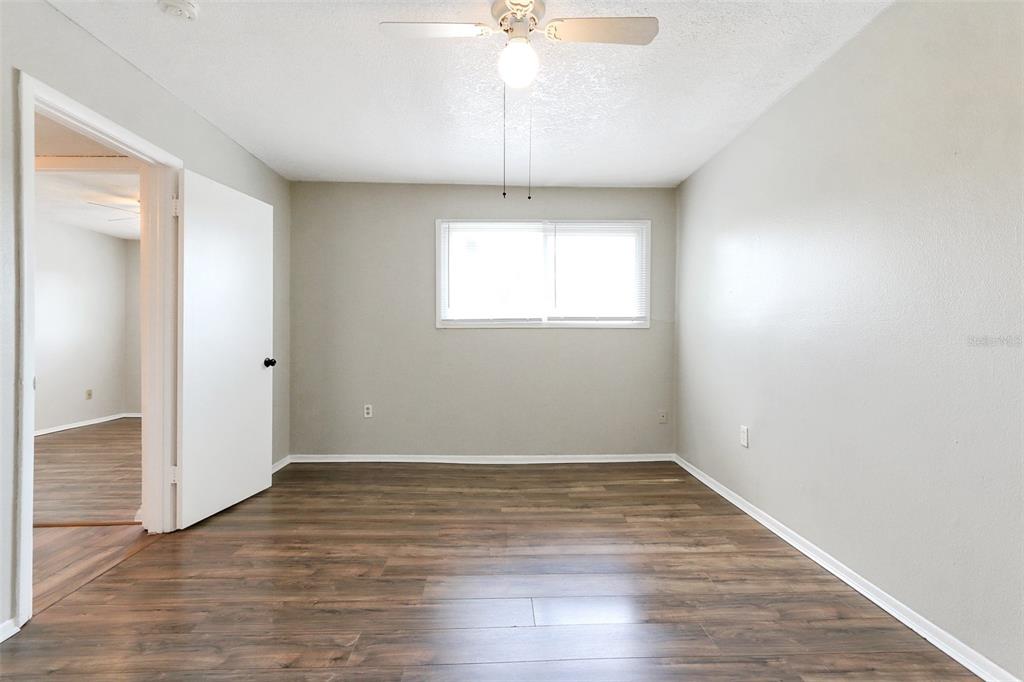 922 Lake Destiny Road, Unit E Altamonte Springs, FL 32714 - Photo 22 of 24 an empty room with wooden floor chandelier fan and windows