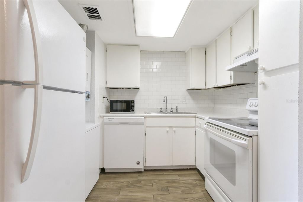 922 Lake Destiny Road, Unit E Altamonte Springs, FL 32714 - Photo 10 of 24 a kitchen with white cabinets and white appliances
