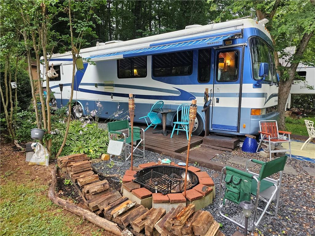 97 Brookside Drive, Unit 58 Cleveland, GA 30528 - Photo 1 of 1 a view of a patio with table and chairs potted plants and large tree