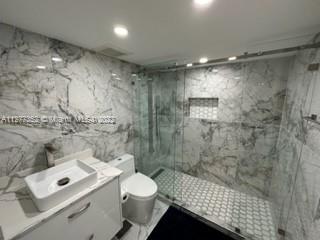 a bathroom with a shower toilet and sink