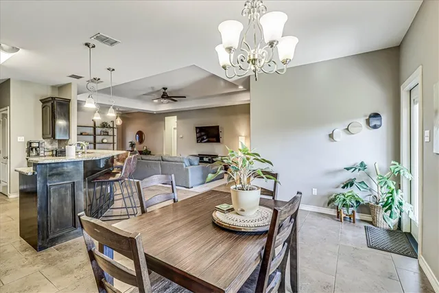 a view of a dining room with furniture a chandelier and wooden floor