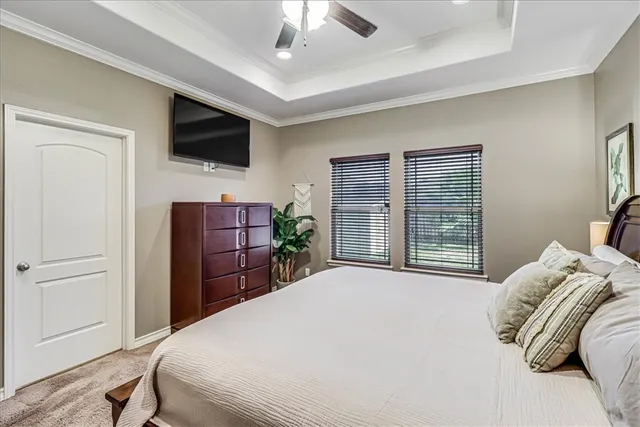 a bedroom with a bed television and a window