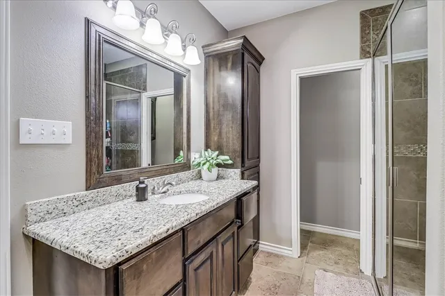 a bathroom with a granite countertop sink and a mirror