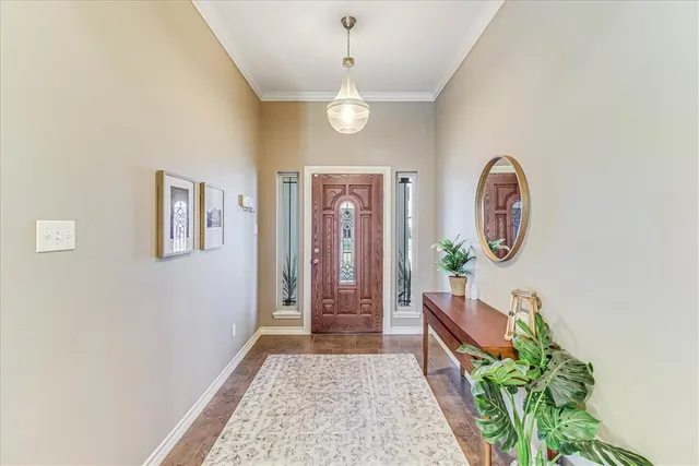 a view of a hallway with wooden floor a door and windows