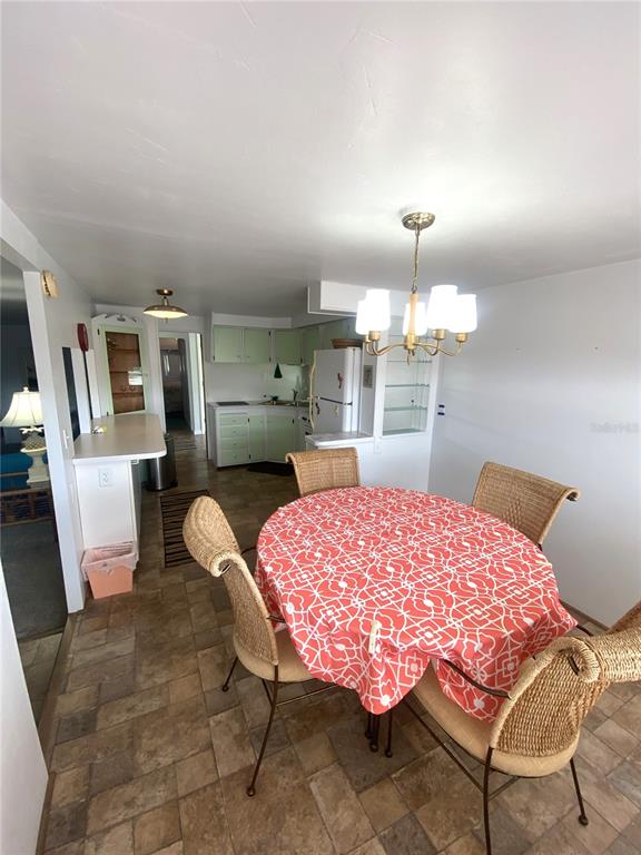 6618 Oregon Street Bradenton, FL 34207 - Photo 18 of 43 a dining room with a table chairs and kitchen view