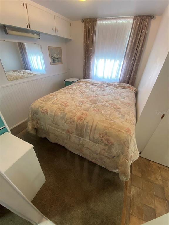 6618 Oregon Street Bradenton, FL 34207 - Photo 34 of 43 a bed sitting in a bedroom next to a lamp