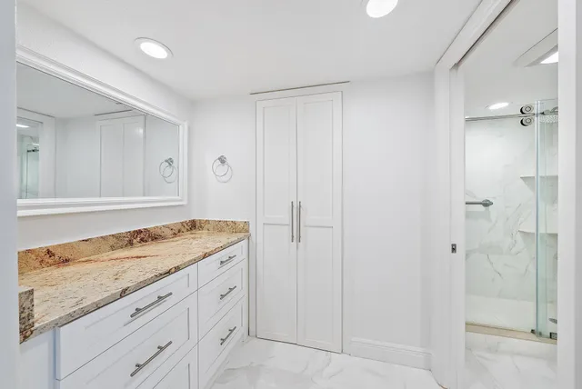 a bathroom with a granite countertop sink toilet and shower