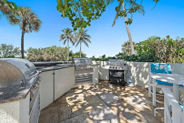 a view of a swimming pool with lawn chairs under an umbrella