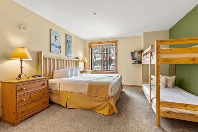 a spacious bedroom with a bed and a lamp