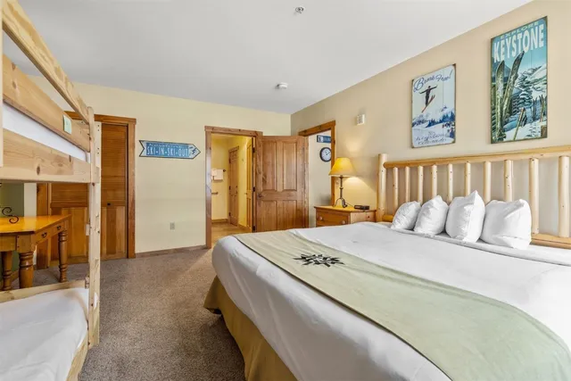 a spacious bedroom with a bed and a chandelier