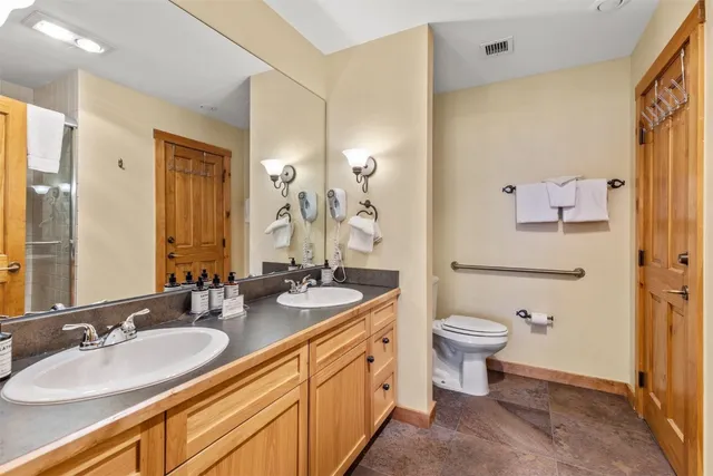 a bathroom with a double vanity sink toilet and shower