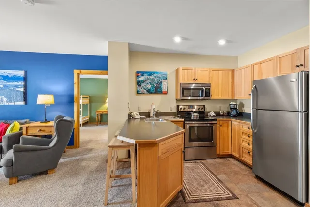 a kitchen with a refrigerator a stove a microwave a sink and a counter top space